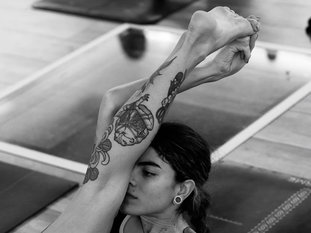 Detalle en blanco y negro de una pierna elevada en práctica de yoga