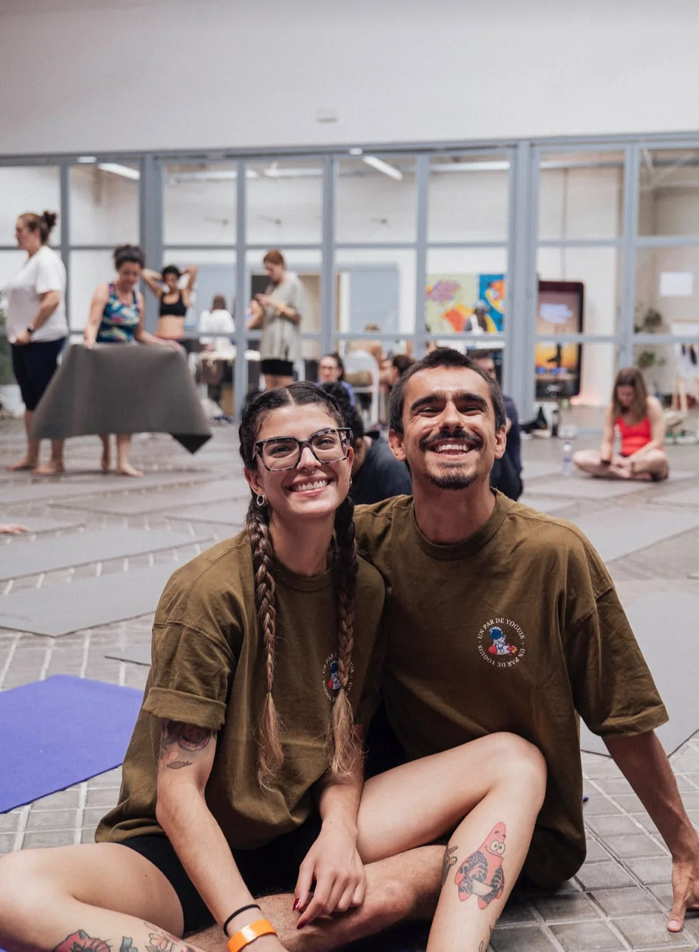 Mafer y Luis sonriendo sentados en un espacio de práctica